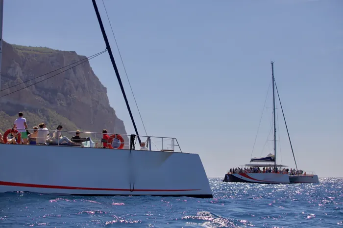 Deux maxi-catamarans au mouillage sous la falaise du cap Canaille