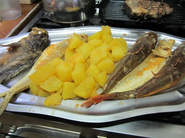 Le plat de bouillabaisse : poissons entiers et pommes de terre sur un grand plateau