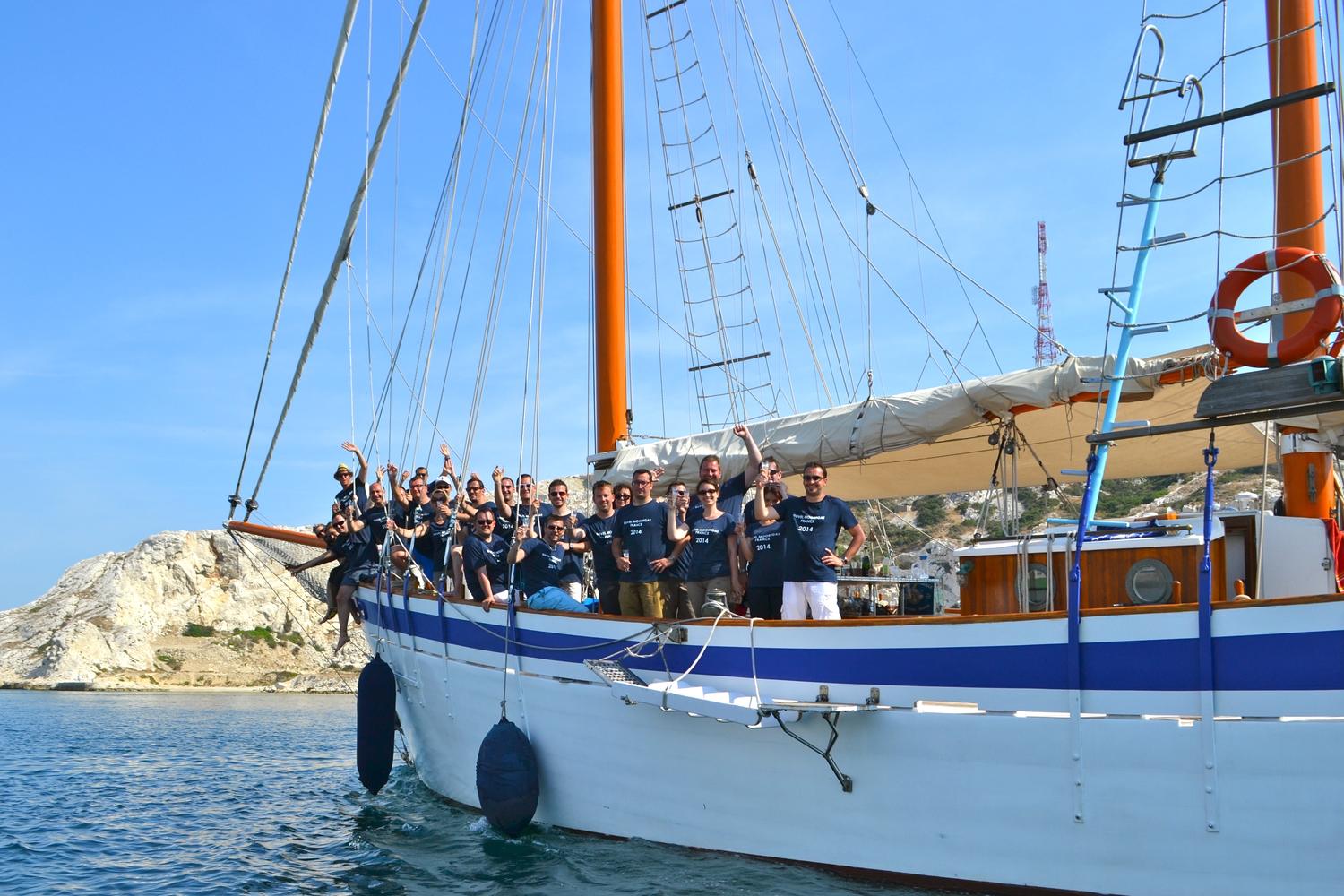 Groupe d'entreprise à bord d'un vieux gréement, devant les falaises blanches du Frioul