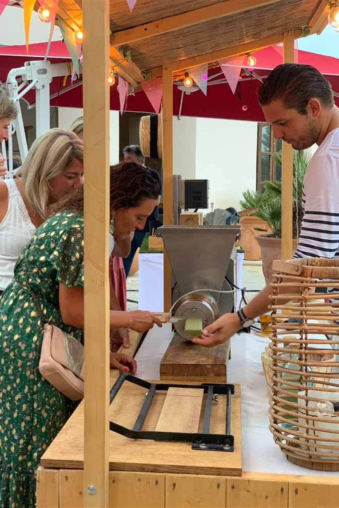 Le savonnier presse un savon de Marseille devant les invités