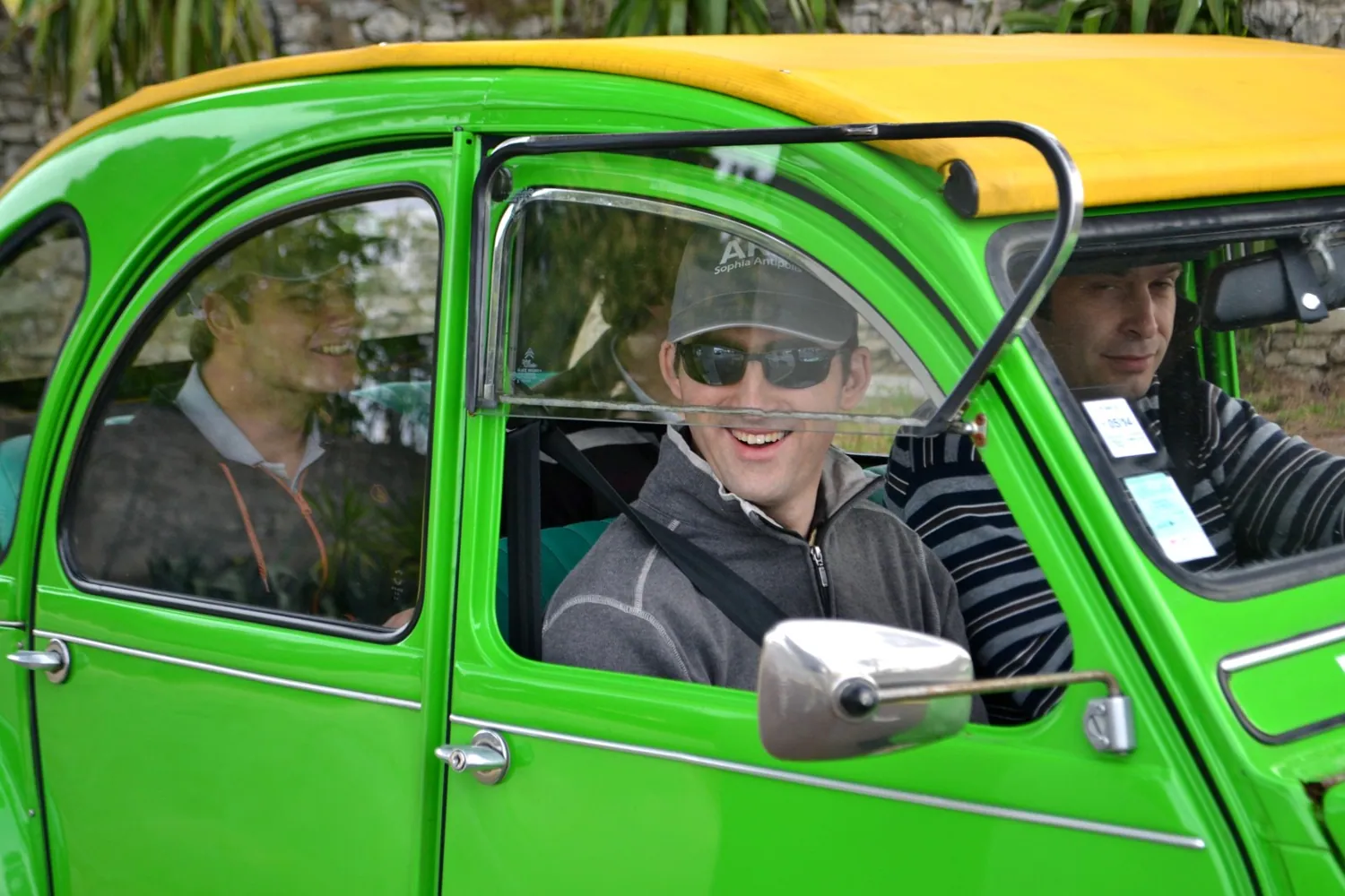 Deux participants au volant d'une 2 CV verte, pendant le rallye