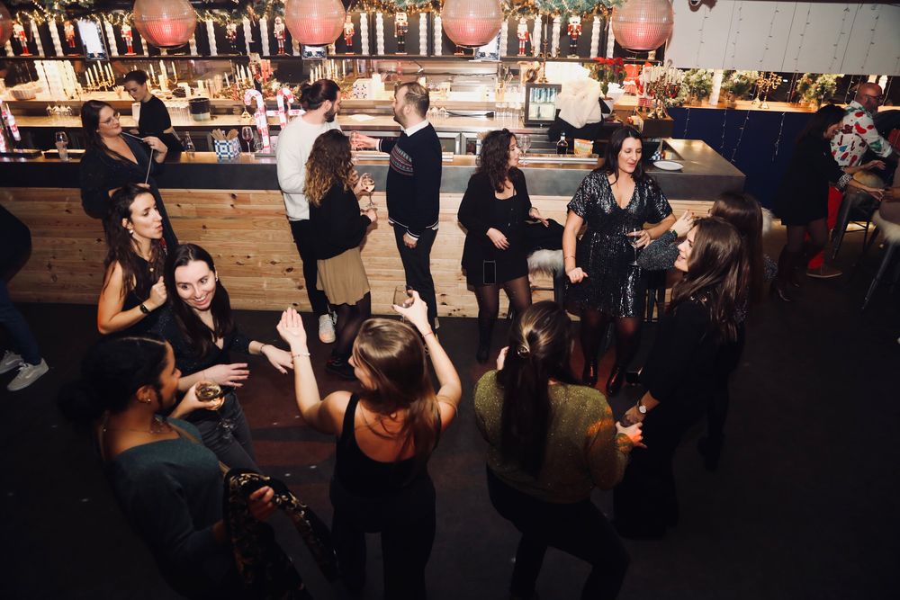 Invités réunis autour du bar pendant le cocktail, sous les lanternes
