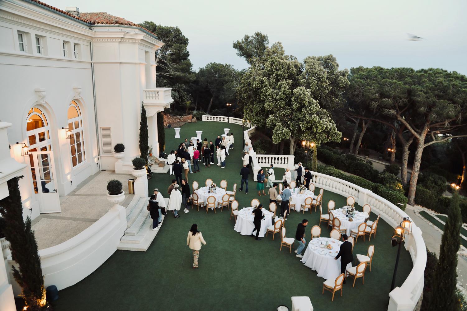 Équipe réunie dans le jardin d'une villa en bord de mer, entre les pins, pendant un offsite