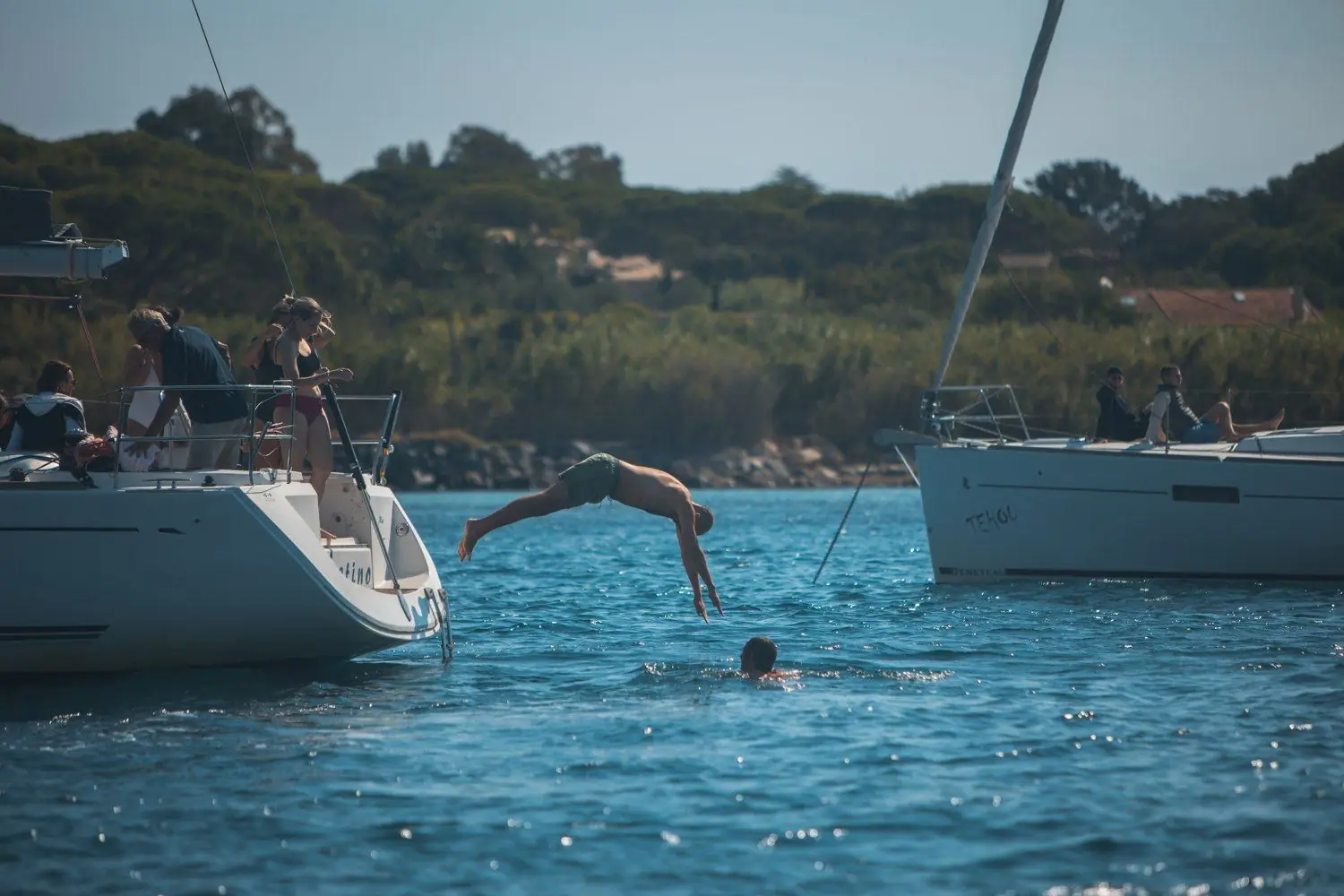 Plongeon depuis l'étrave d'un voilier au mouillage