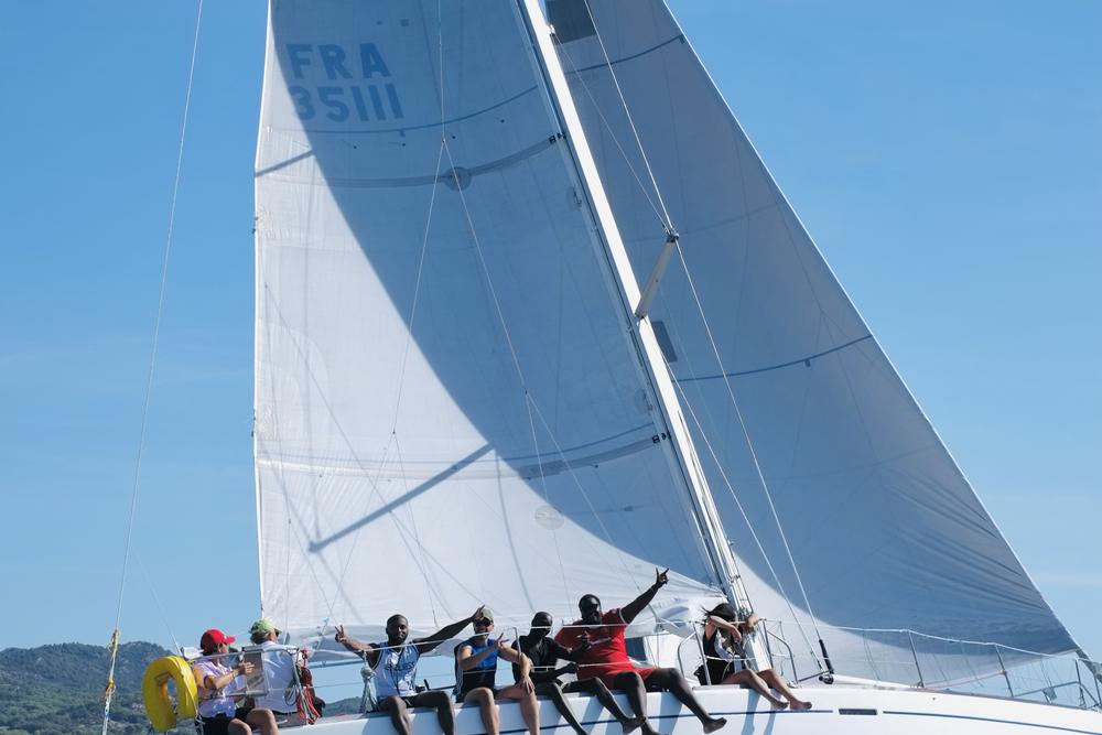 Équipage d'entreprise assis sur le bord d'un voilier pendant une régate