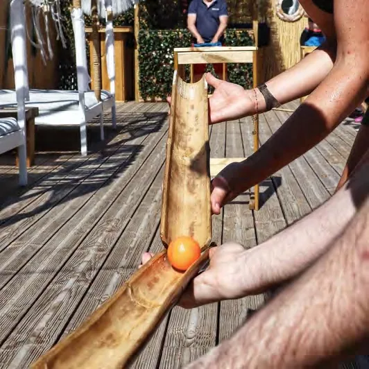 Épreuve d'adresse : faire rouler une balle sur un bambou, à plusieurs mains