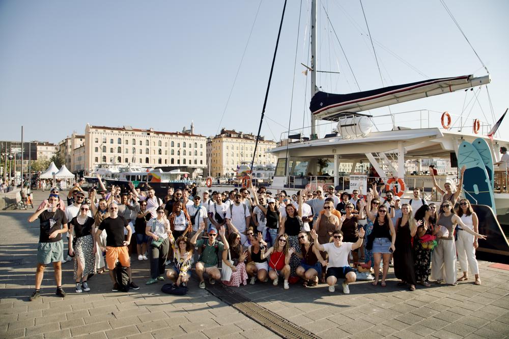 Groupe réuni sur le quai du Vieux-Port devant un catamaran
