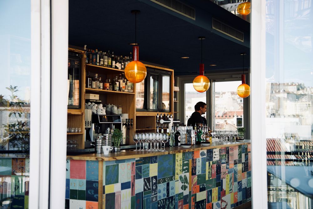 Bar d'un rooftop aux carreaux colorés, face à la ville