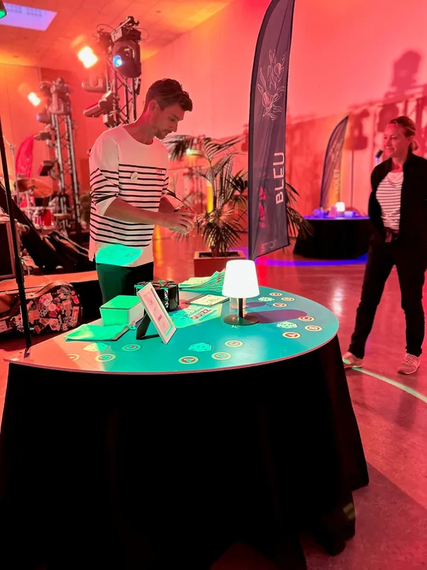 Une table de quiz ronde éclairée par une lampe, dans une salle rouge