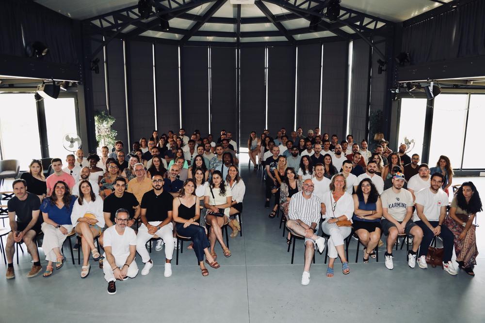 Participants d'une convention assis en plénière dans une grande salle vitrée