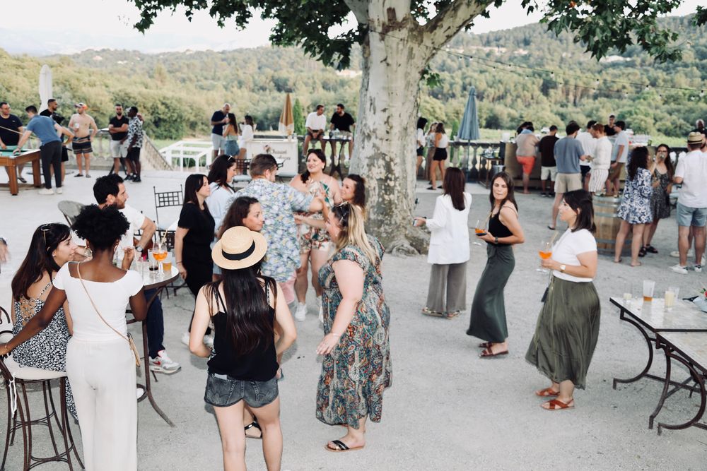 Invités qui dansent sur la terrasse d'un domaine, sous les platanes