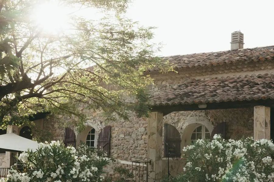 Mas en pierre au milieu des arbres et des fleurs