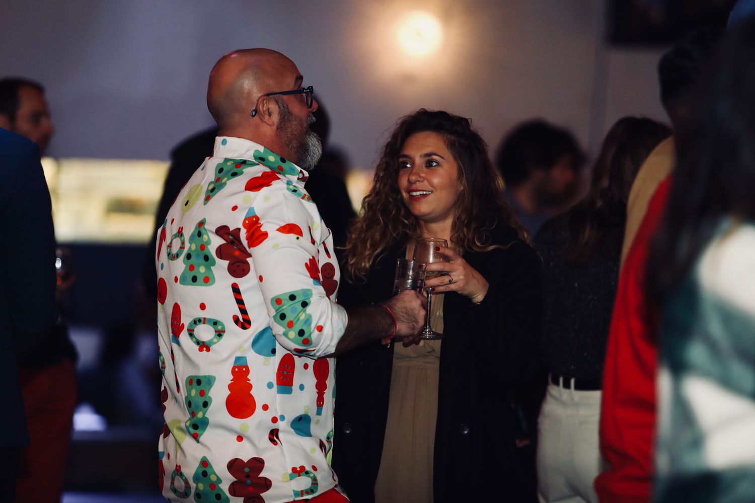 Collègues en chemise de Noël, un verre à la main, pendant la fête de Noël de l'entreprise