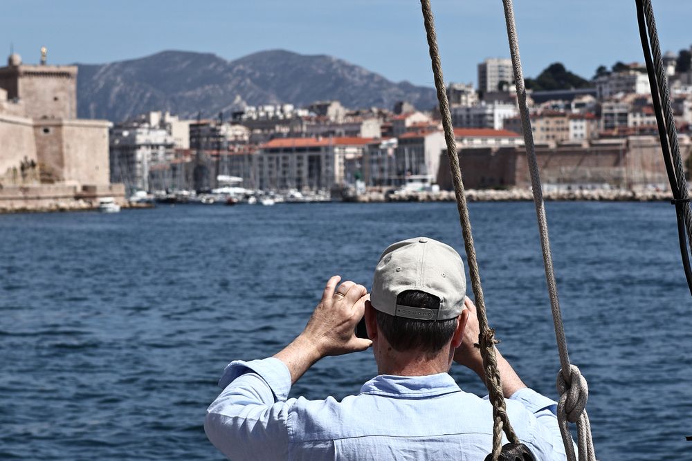 Participant qui photographie le Vieux-Port depuis le pont d'un voilier