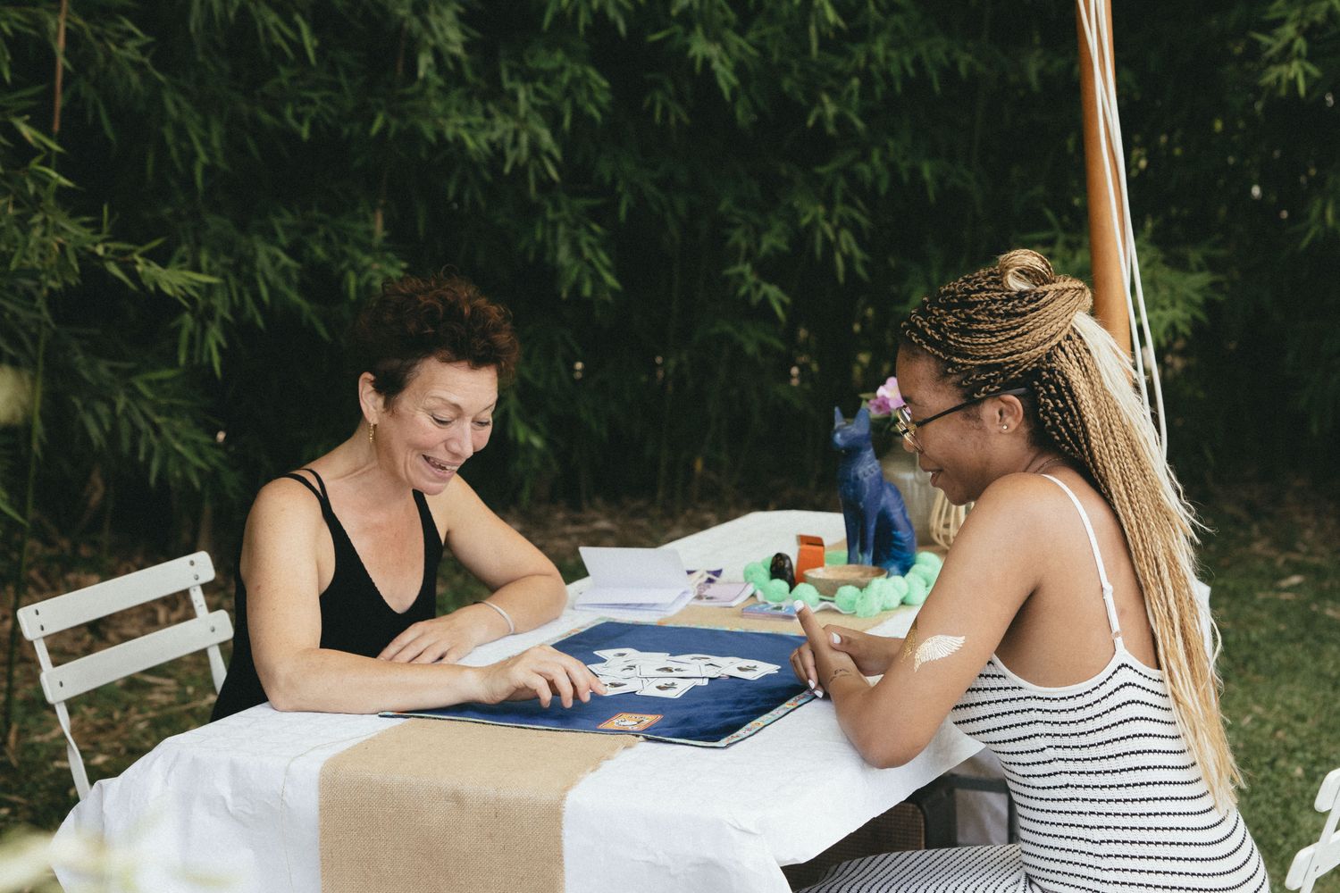 Deux participantes face à face autour d'un atelier posé sur une table, au jardin