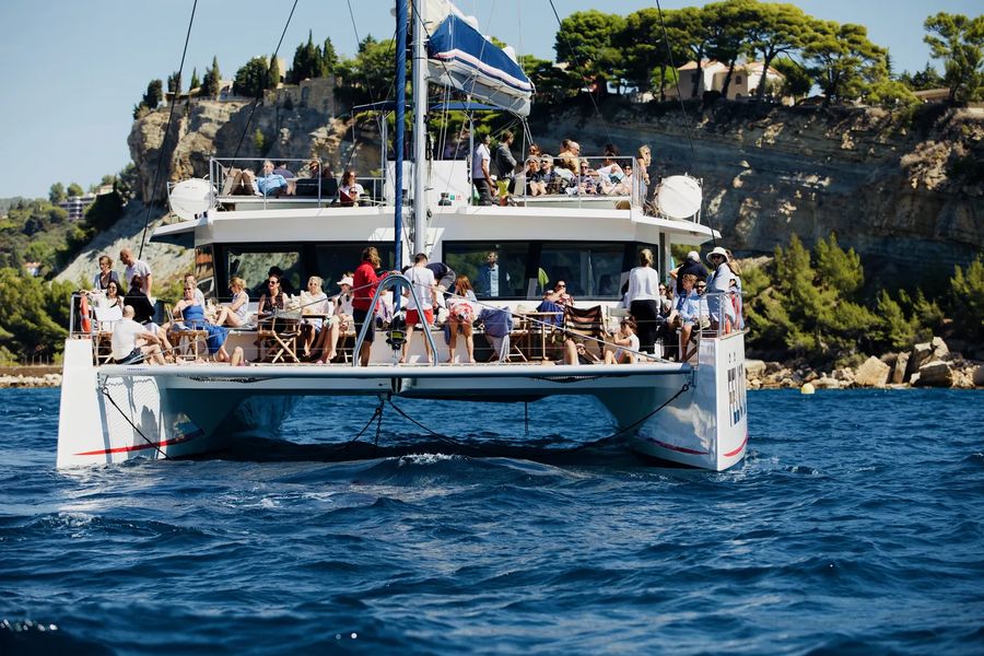 Maxi-catamaran longeant une pointe boisée