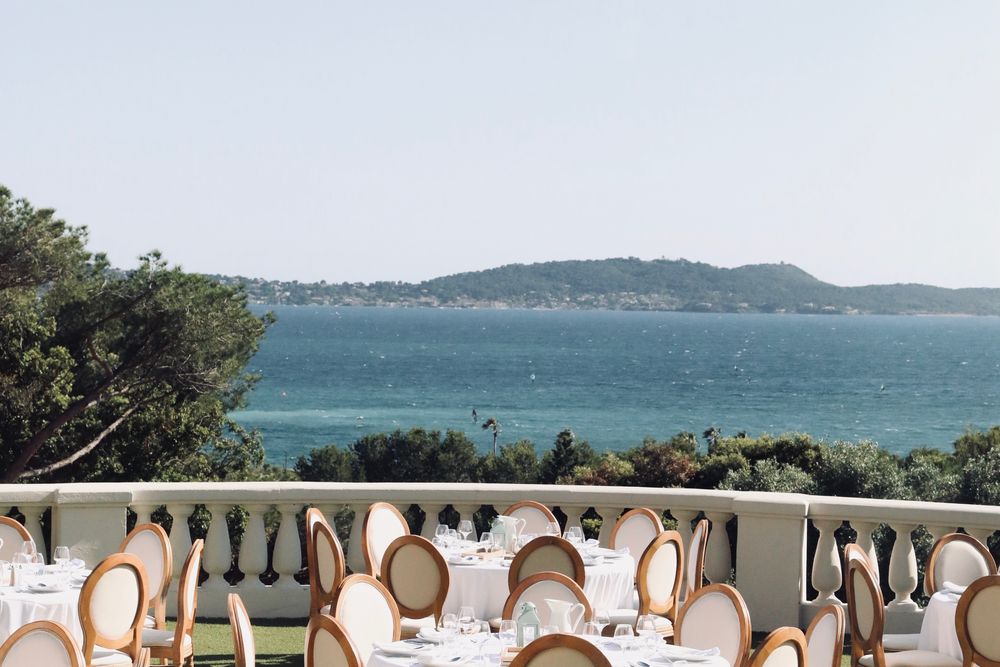 Tables dressées sur la terrasse d'une villa, face à la baie