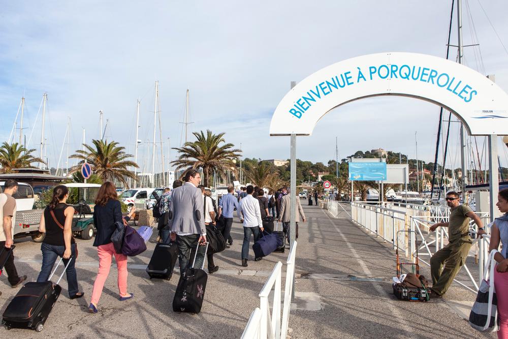 Participants débarquant sous l'arche « Bienvenue à Porquerolles »