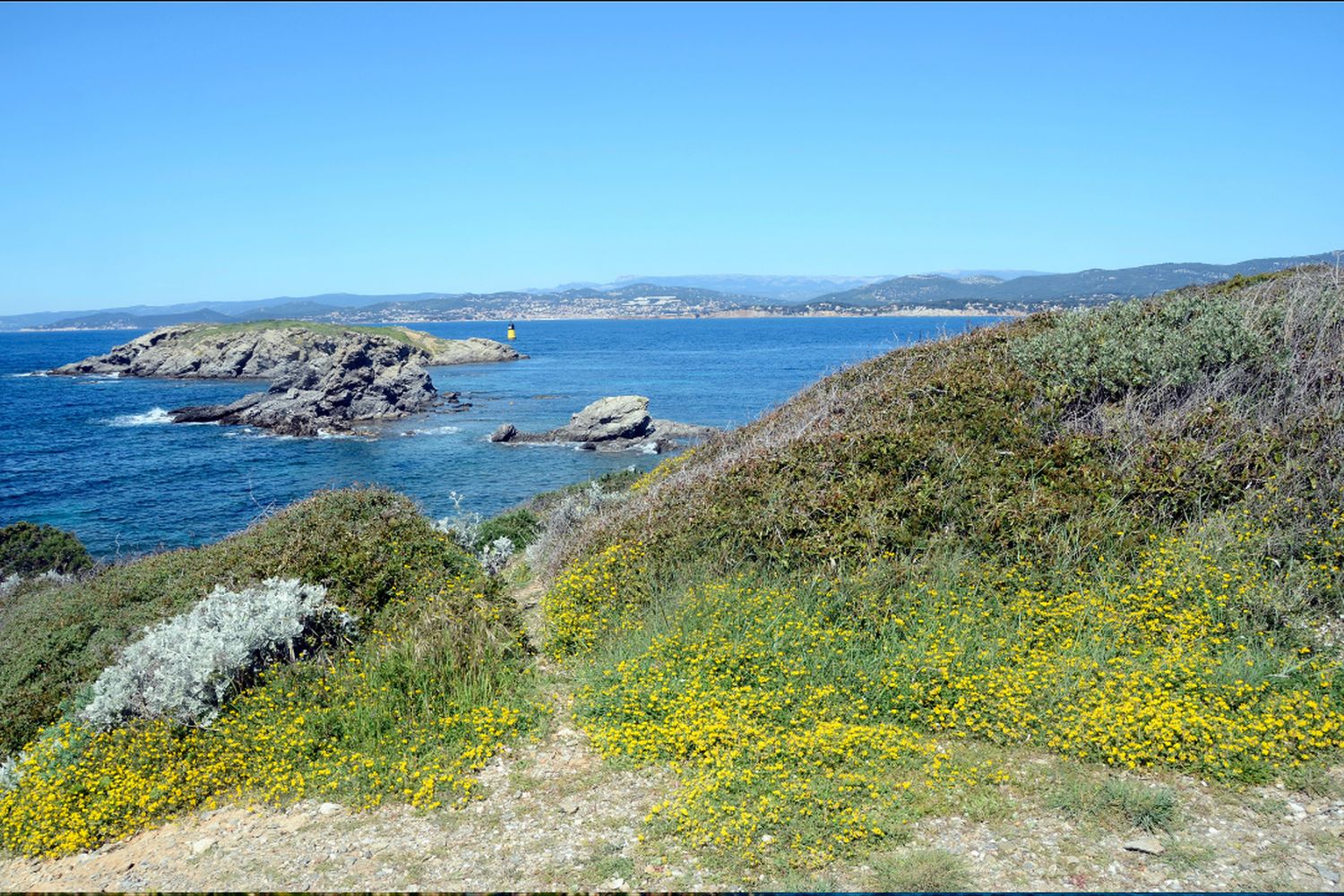 Sentier du littoral fleuri au-dessus de la mer et des îlots