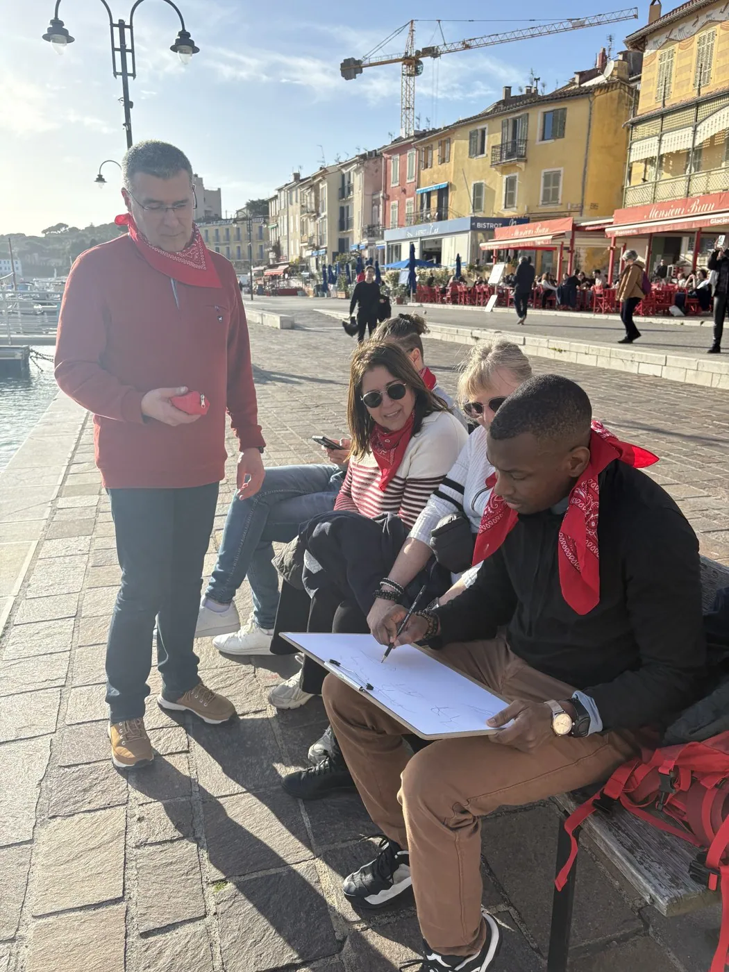 Une équipe au travail sur son carnet de route, sur le port de Cassis