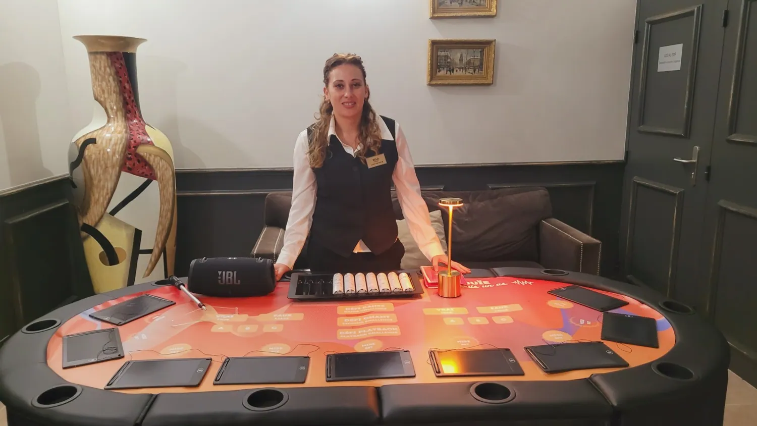 Table éclairée en rouge, jetons alignés devant le croupier