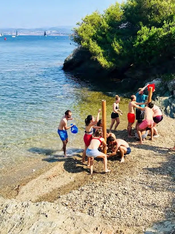 Équipe d'entreprise sur une plage de galets, épreuve d'un challenge nature