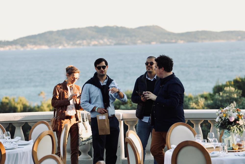 Participants d'un séminaire sur une terrasse face à la mer