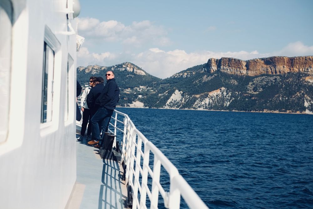 Invités à la proue d'un bateau, face aux falaises du cap Canaille