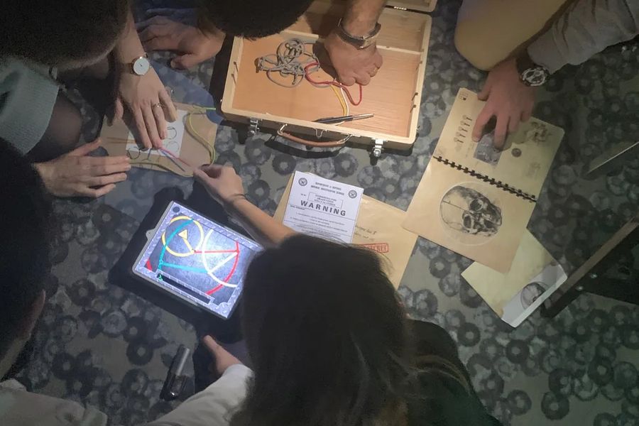 Participants penchés sur les énigmes d'un escape game