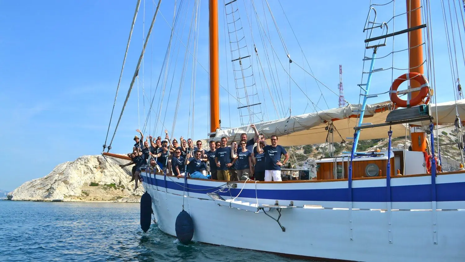 Groupe rassemblé sur le pont d'un vieux gréement, devant un îlot