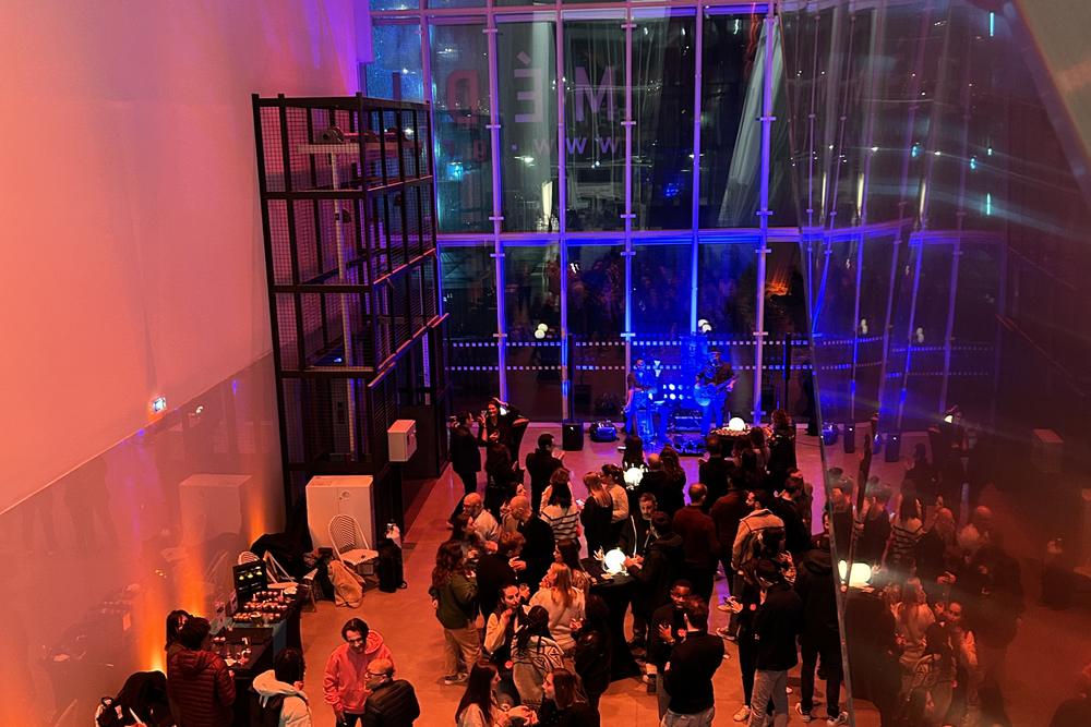 Soirée de lancement dans une grande salle vitrée éclairée en orange et bleu