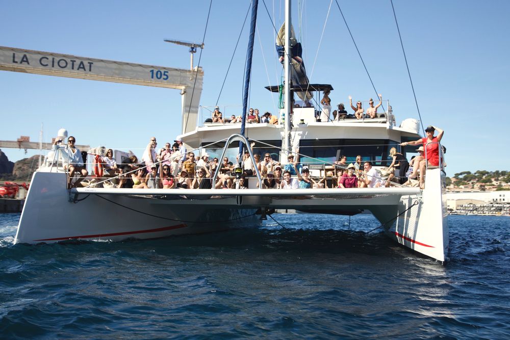 Groupe à bord d'un maxi-catamaran devant le portique des chantiers de La Ciotat