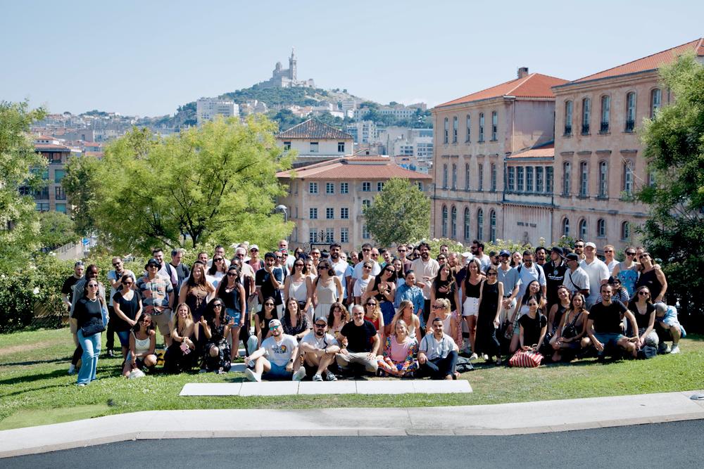 Grand groupe réuni dans un jardin de Marseille, Notre-Dame-de-la-Garde en fond