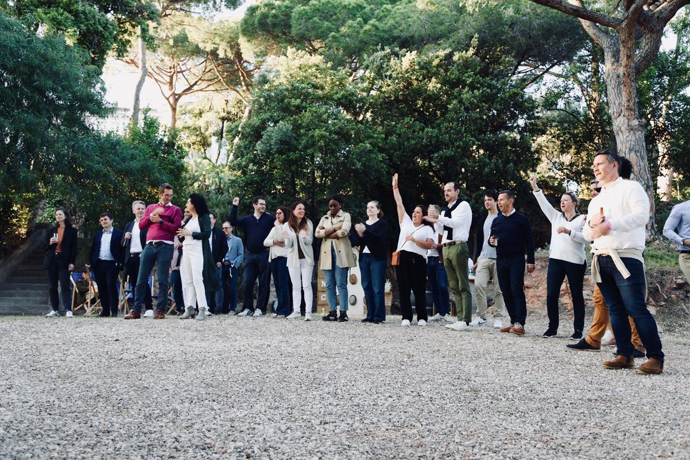 Invités réunis dans un jardin sous les pins, pendant le discours