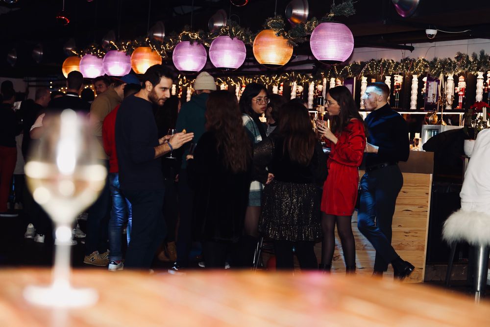 Invités au bar sous les lanternes roses et les guirlandes