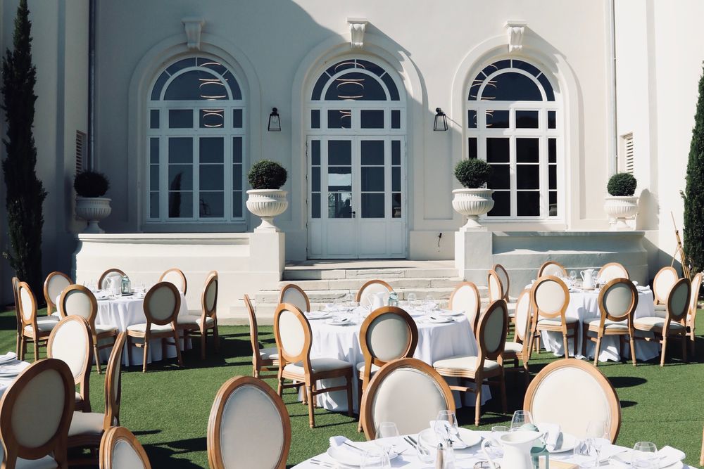 Tables dressées sur la pelouse d'une demeure provençale, avant le dîner