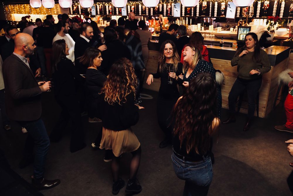 Piste de danse d'une soirée d'entreprise, au pied d'un grand bar éclairé