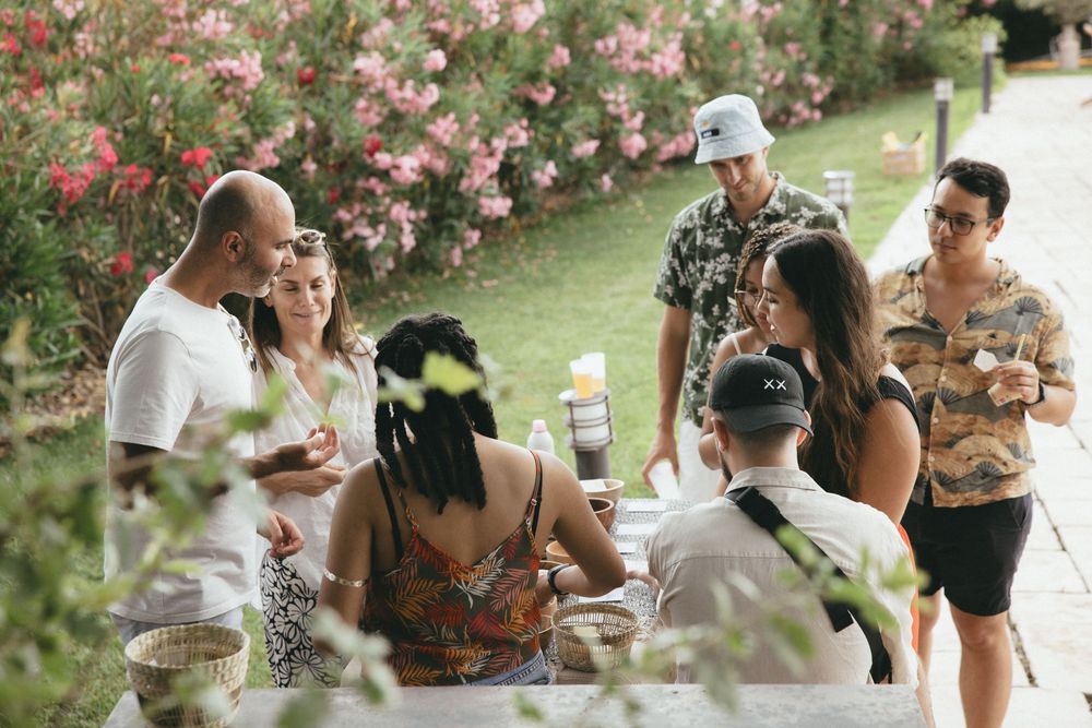 Petit groupe réuni autour d'une table, dans une allée de lauriers roses