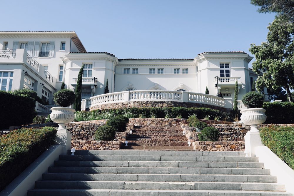 Grand escalier d'une demeure blanche, entrée des invités