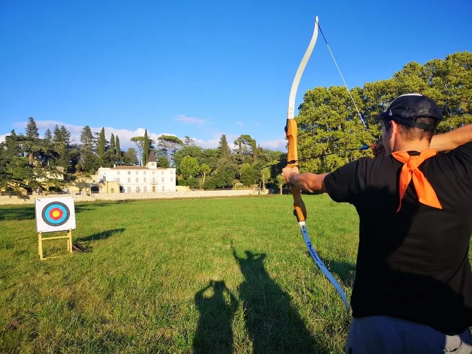 Atelier de tir à l'arc devant la bastide d'un domaine viticole